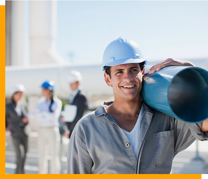 A man in hard hat holding a pipe.