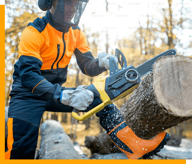 A person in an orange and black shirt sawing wood