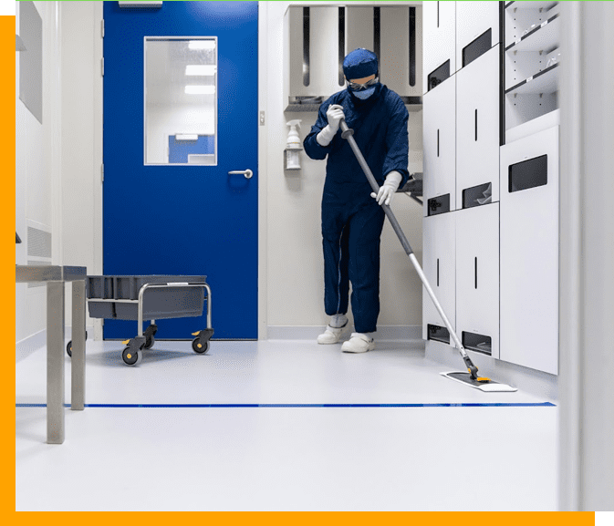 A man in blue coveralls and mask cleaning.