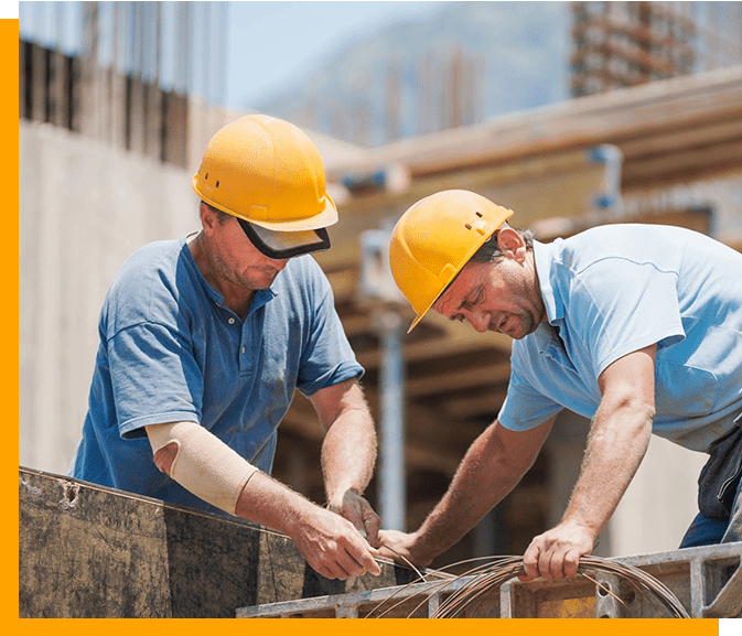 Two men in hard hats working on a construction site.