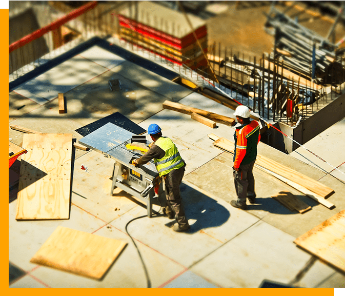 Two construction workers are working on a building.