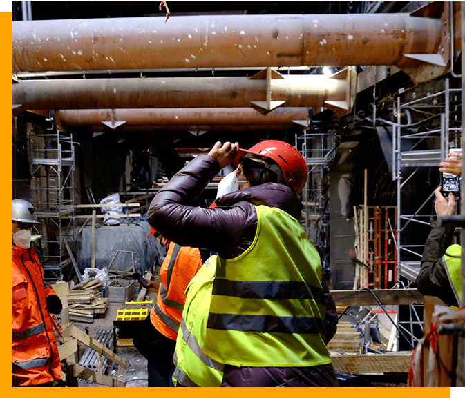 A man in yellow vest and red hard hat.