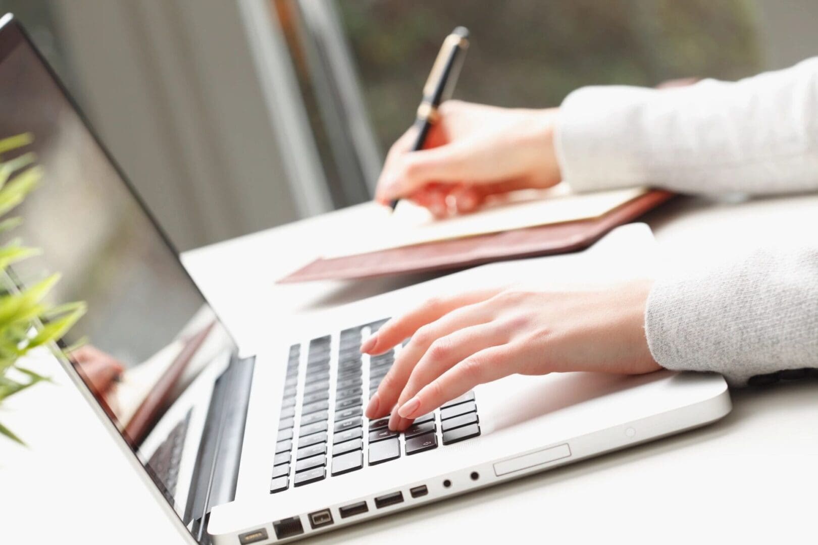 A person typing on a laptop with a tie