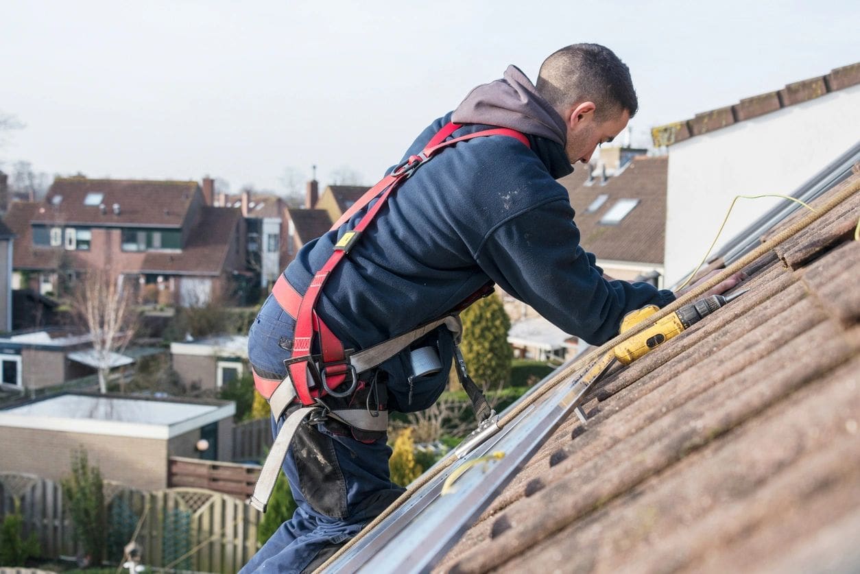 A man working on the roof of his house.