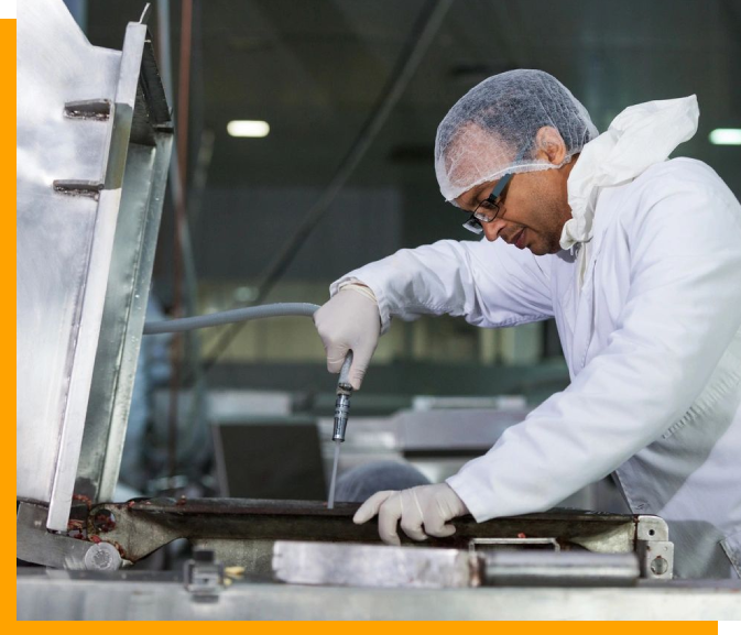 A man in white lab coat and goggles working on a piece of glass.