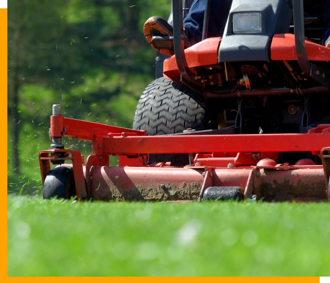 A person on a lawn mower in the grass.