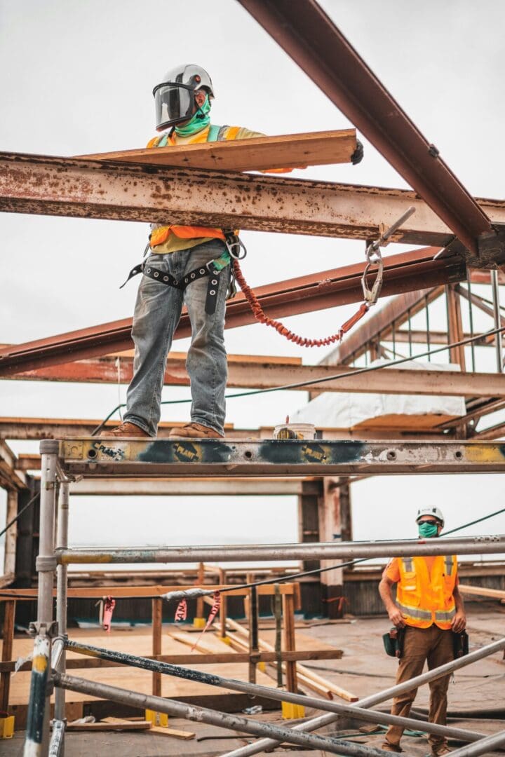 A man standing on top of a metal beam.