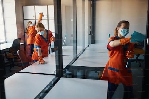 A woman in orange is cleaning the floor